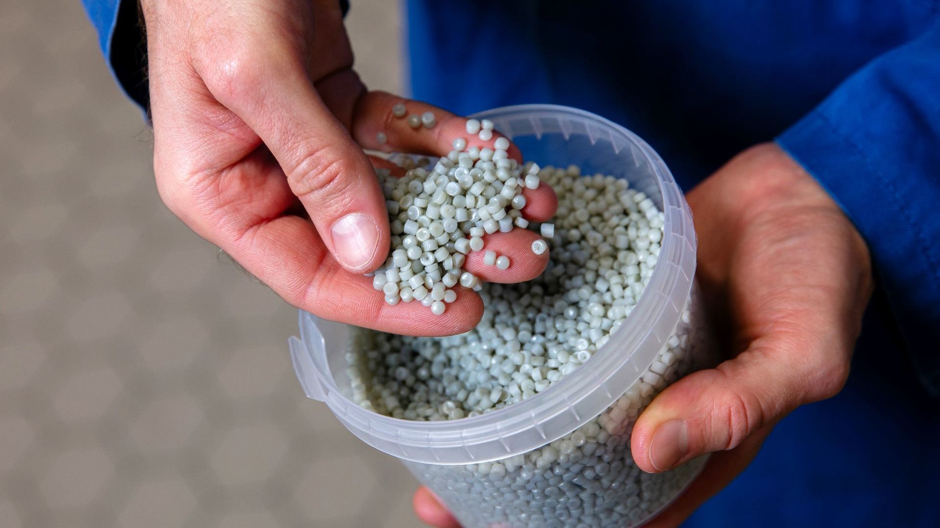 Unilever-wetenschapper met een handvol korrels gerecycled plastic