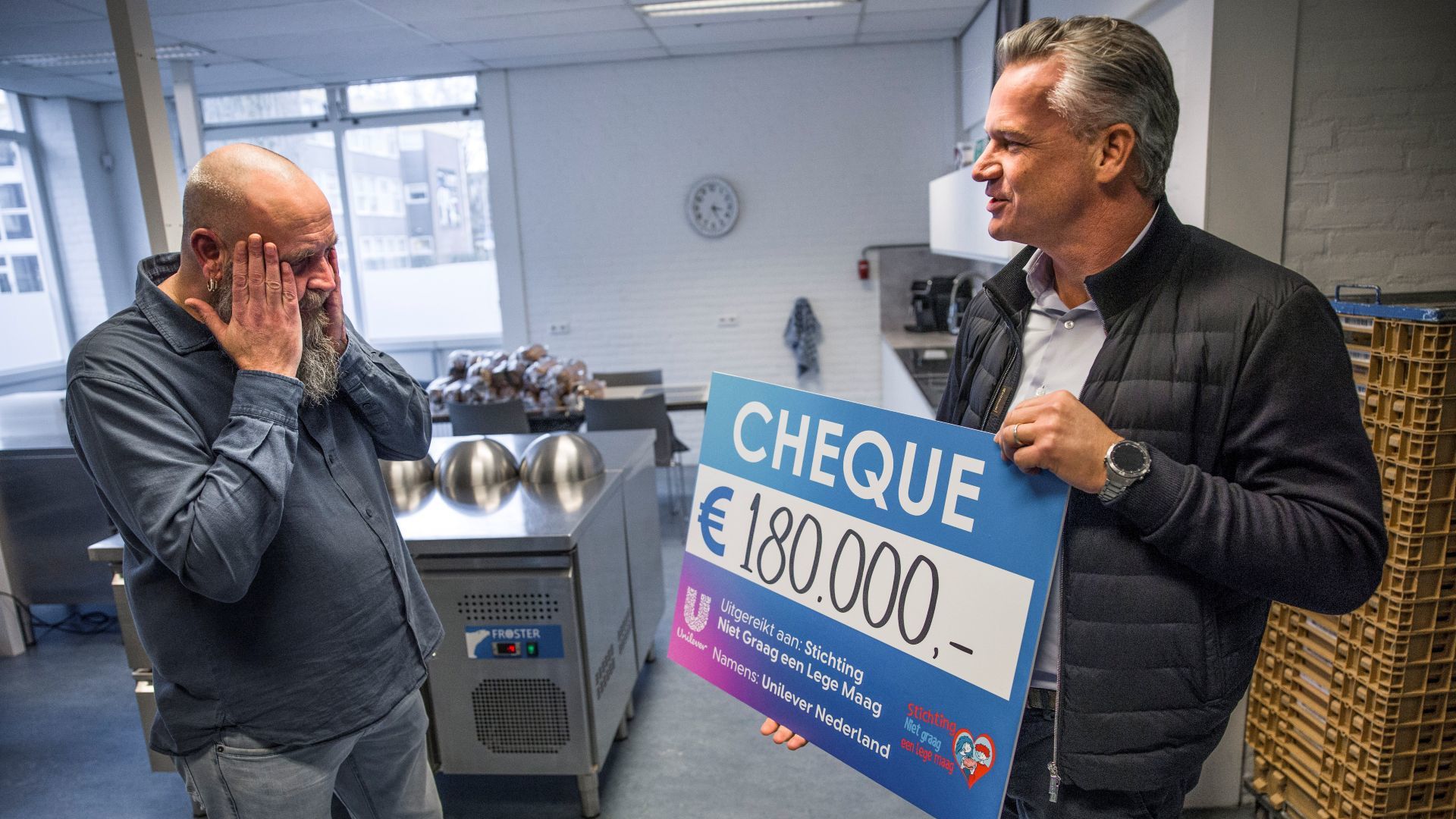 Op links Johan de Boterhammenman vol ongeloof kijkend naar cheque van €180.000 geschonken door Unilever.